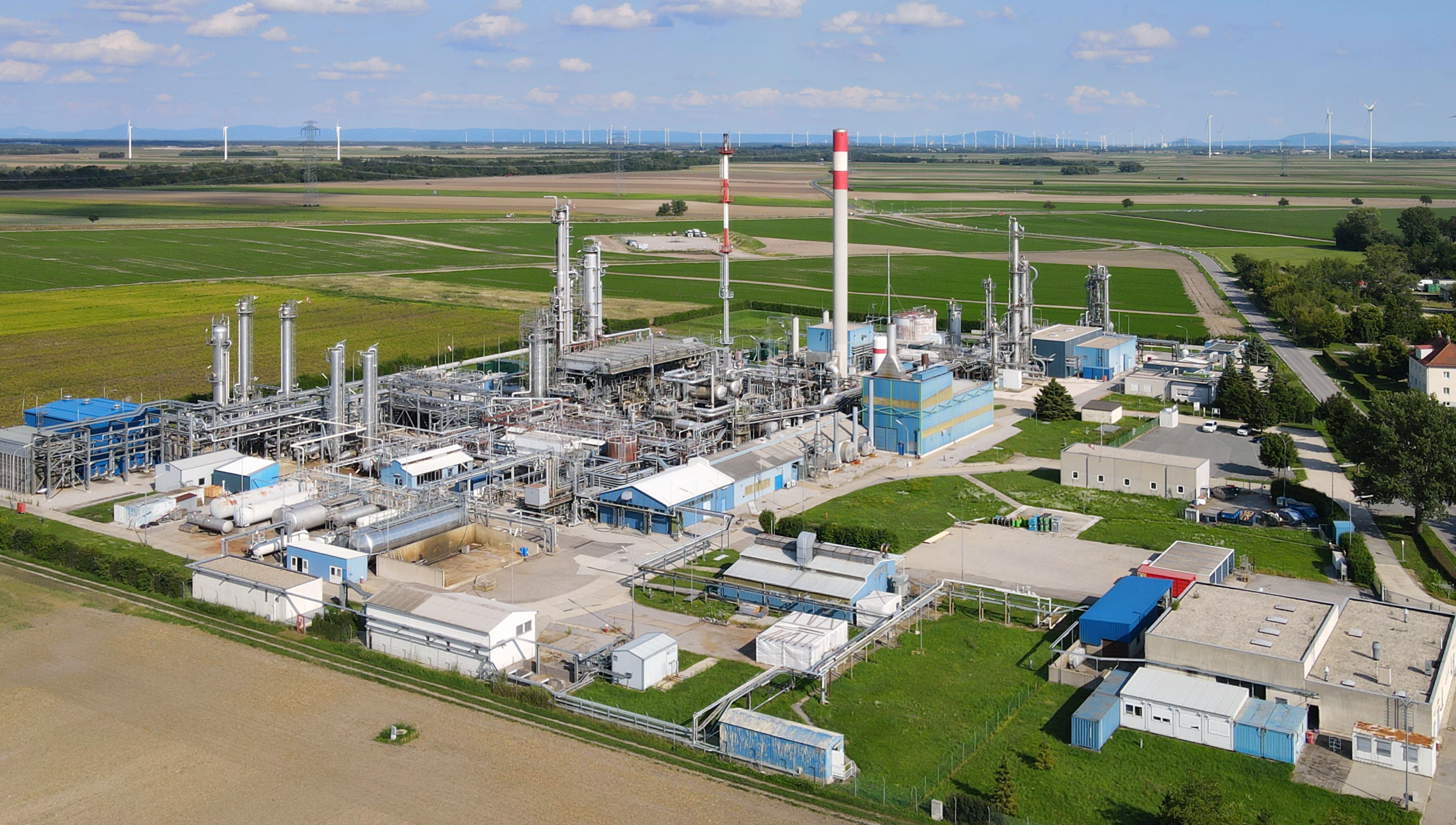 Aerial view of a natural gas processing plant in Aderklaa, Lower Austria, with fractionation columns and pipeline infrastructure