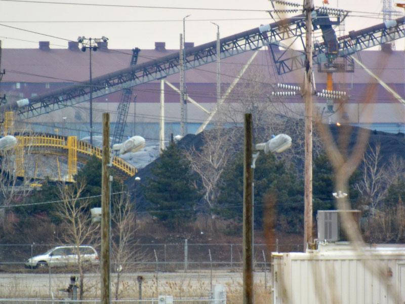 A massive petroleum coke stockpile on Chicago's South Side with a car for scale
