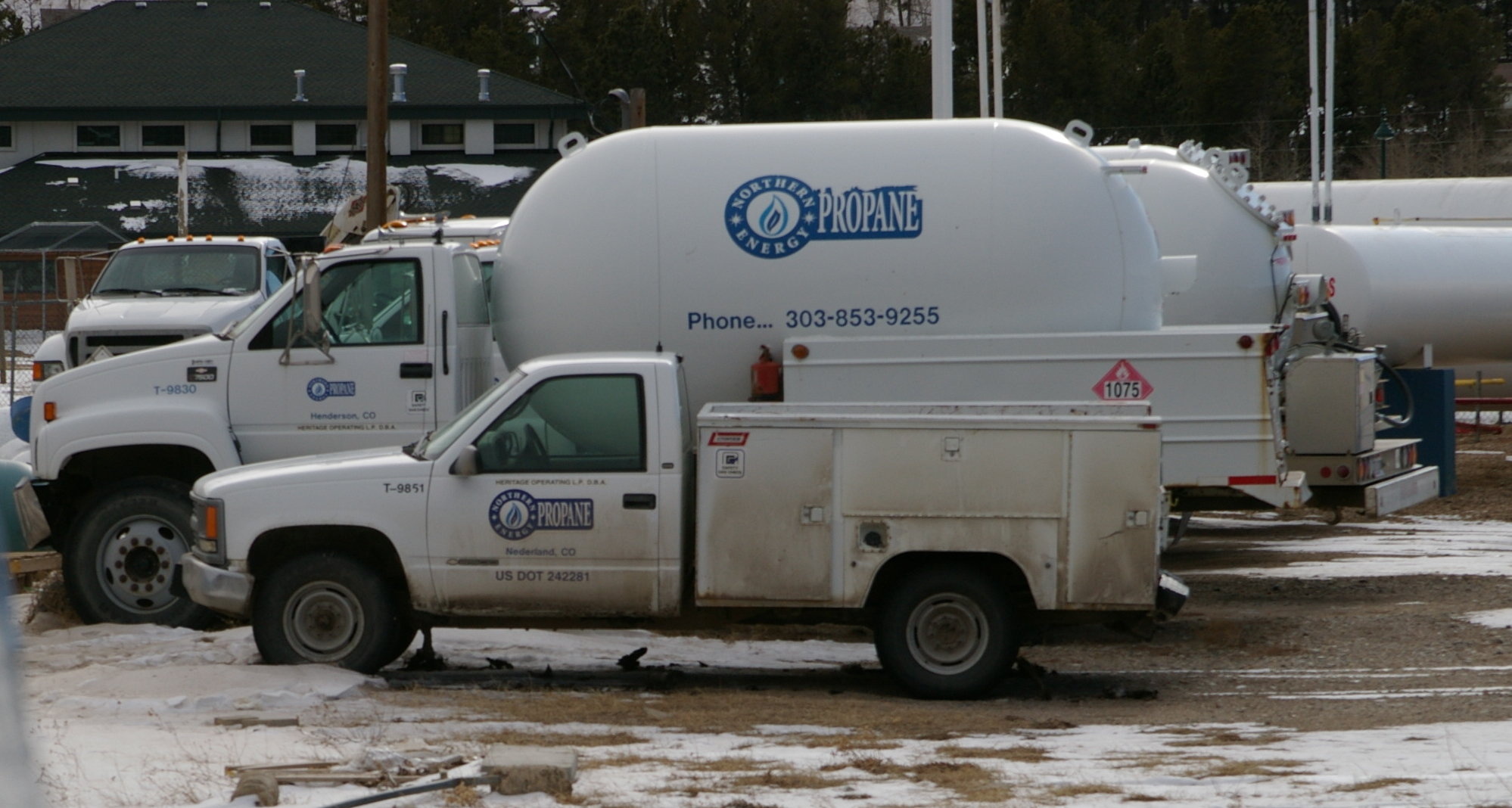 A residential propane delivery bobtail truck parked behind a pickup truck