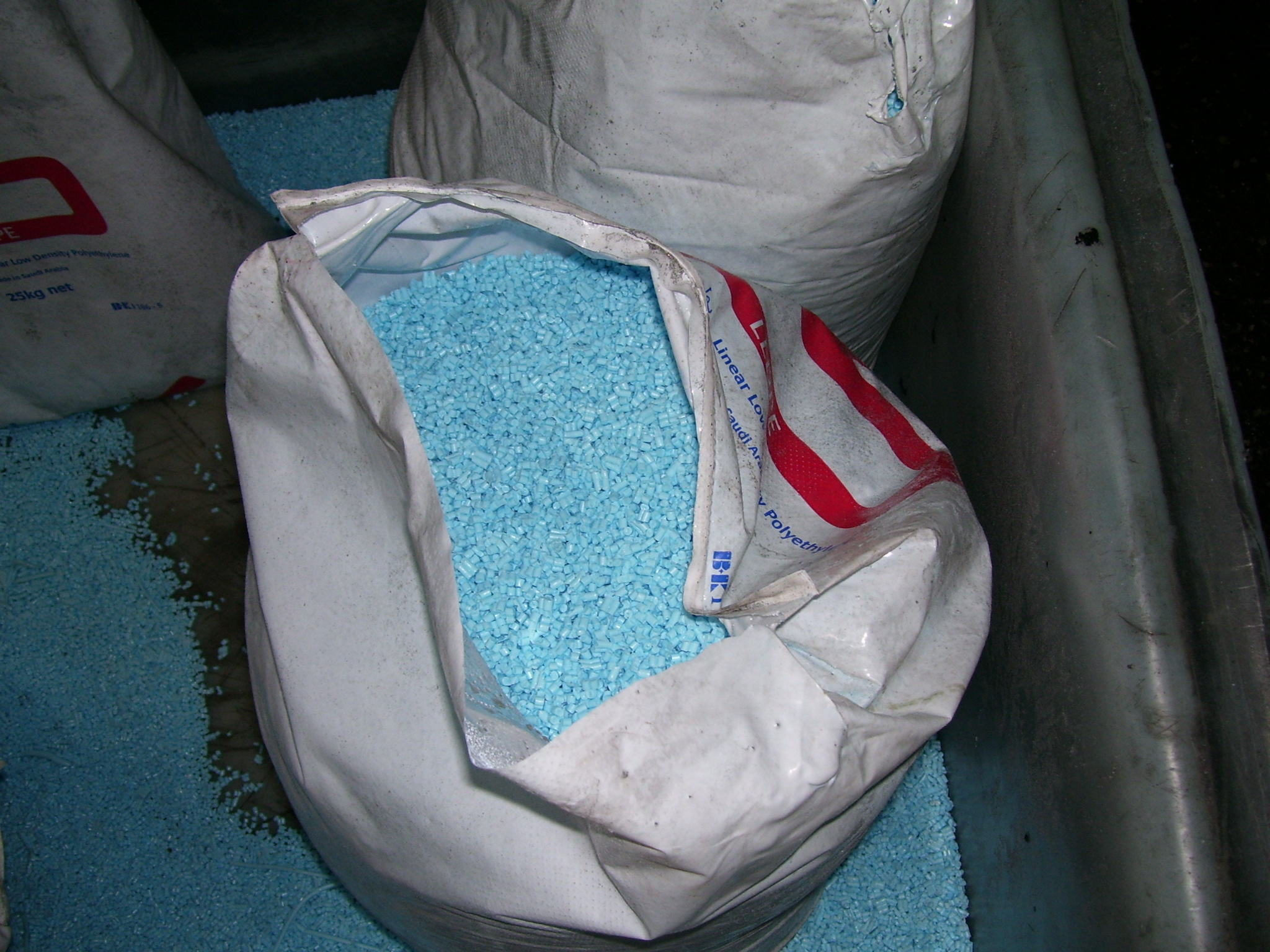 Small translucent plastic pellets (nurdles) used as raw material for rotational moulding