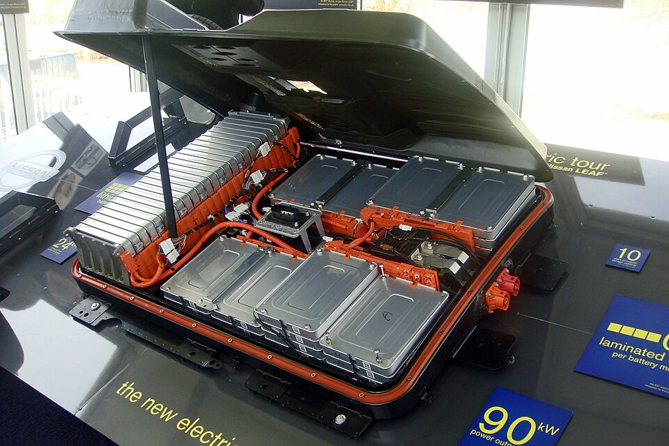 Nissan Leaf lithium-ion battery pack displayed at an auto show, showing the flat pack that sits beneath the passenger cabin